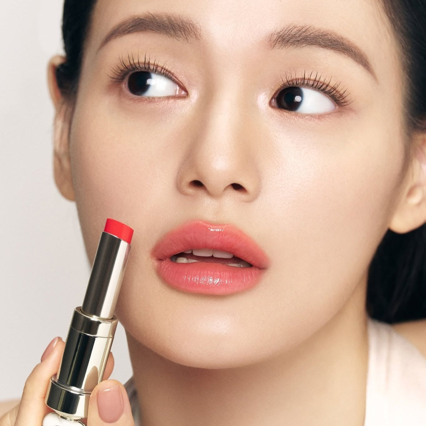 THE WHOO Essentail Lip Glow Balm applied by a model, showcasing vibrant lip shade for a natural look.