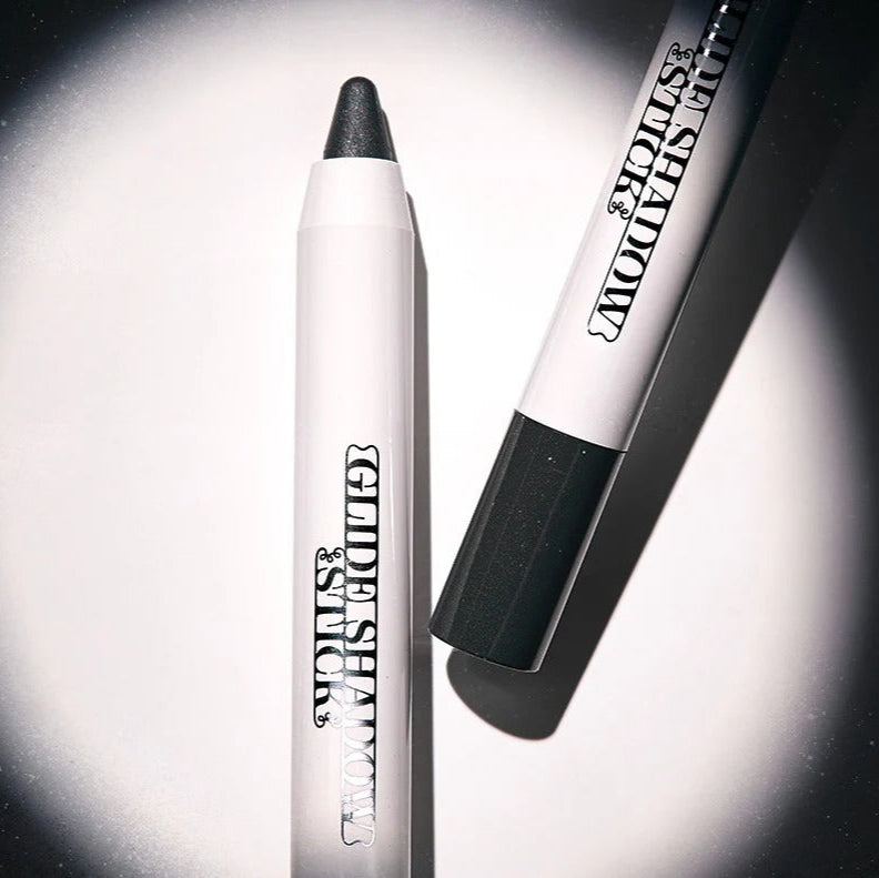 TIP TOE Glide Shadow Stick in a sleek white casing with black cap, photographed on a contrasting background, showcasing product design.