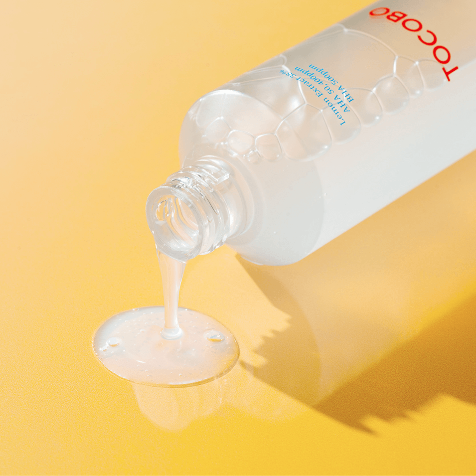 TOCOBO AHA BHA Lemon Toner bottle pouring liquid on yellow background