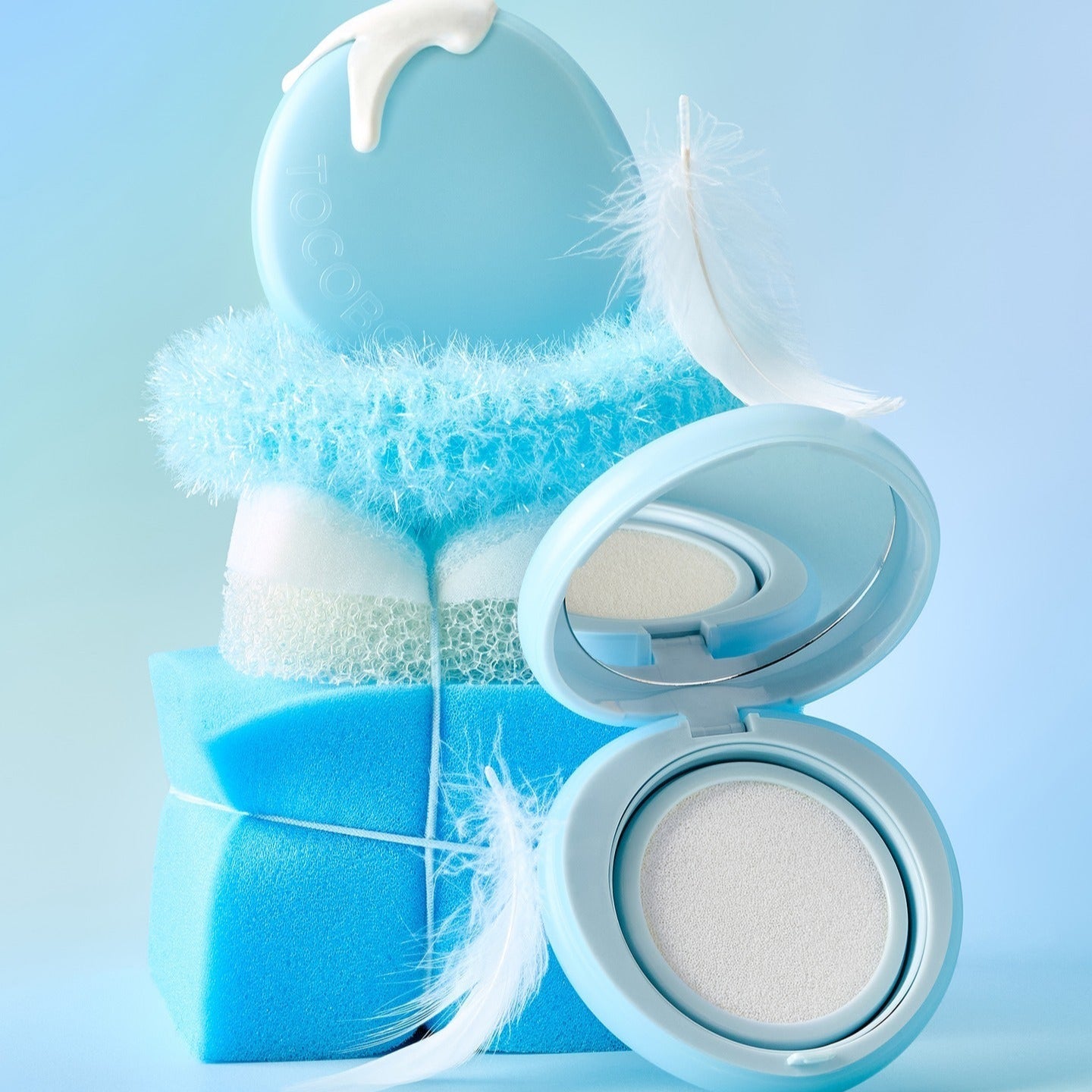 TOCOBO Blur Finish Sun Cushion with blue packaging and feathers, showcasing its protective sun-blocking and skin-smoothing attributes.