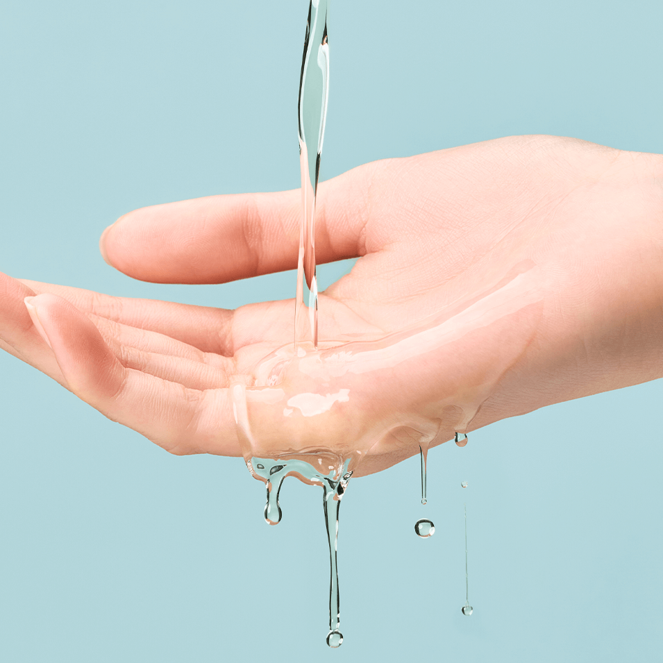 Pouring TOCOBO Cica Calming Aqua Toner onto hand against blue background