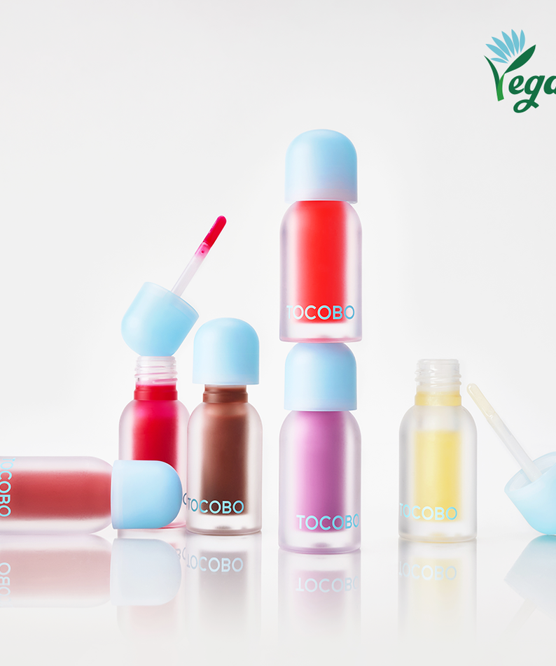 Assorted bottles of TOCOBO Juicy Berry Pluming Lip Oil with a vegan logo on a white background.