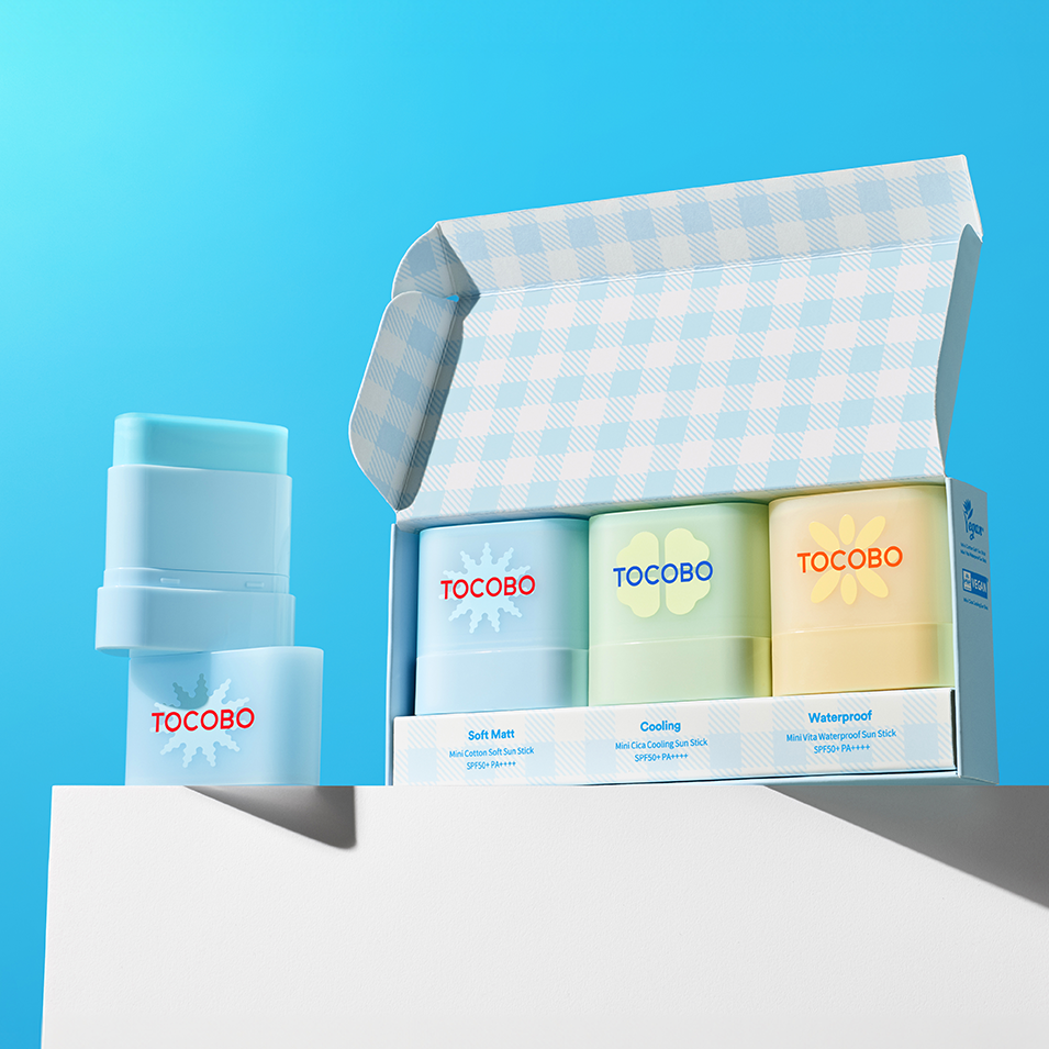 TOCOBO Mini Sun Stick Trio, a set of sun protection sticks displayed with open box against a blue background, SPF 50+ protection.