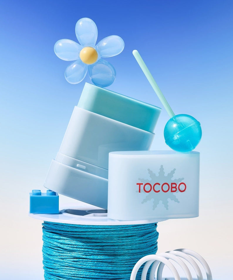 TOCOBO Mini Sun Stick Trio displayed creatively with a floral and blue theme.