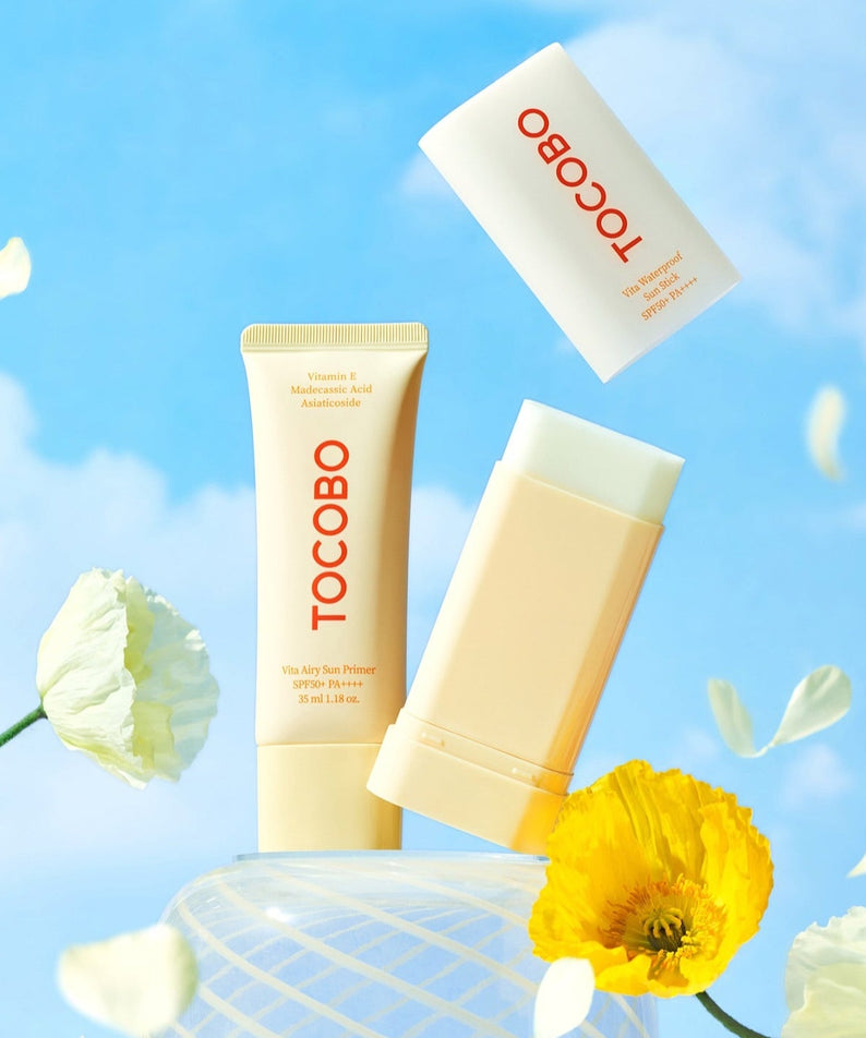 TOCOBO Vita Waterproof Sun Stick displayed with bright flowers against a blue sky background.