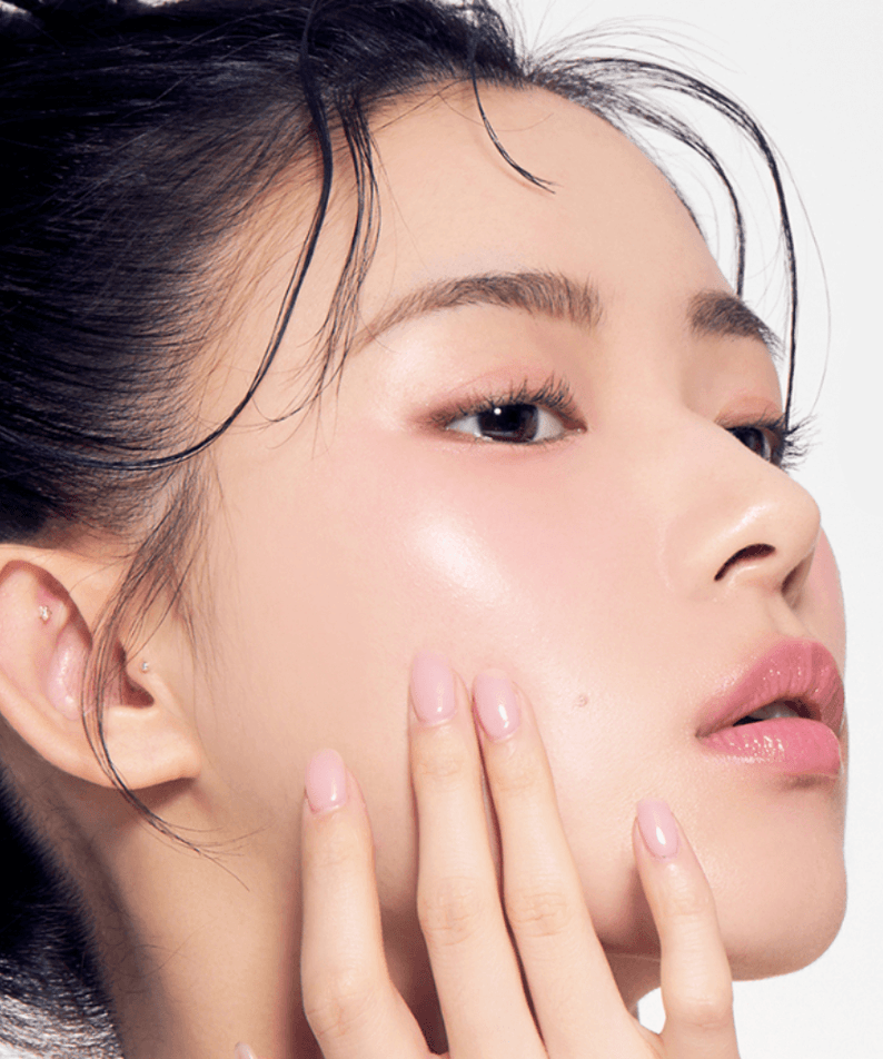 Close-up of a woman with glowing skin and elegant makeup, highlighting the effects of TONY MOLY Eyetone Strong Eye Lash Serum.