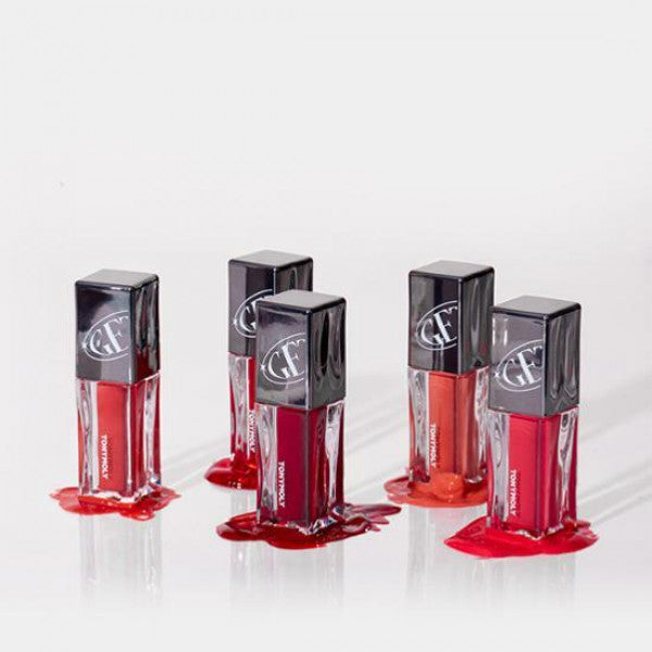 Five bottles of TONY MOLY Get It Tint Colorful Water in various shades displayed with spilled tint on a white background.