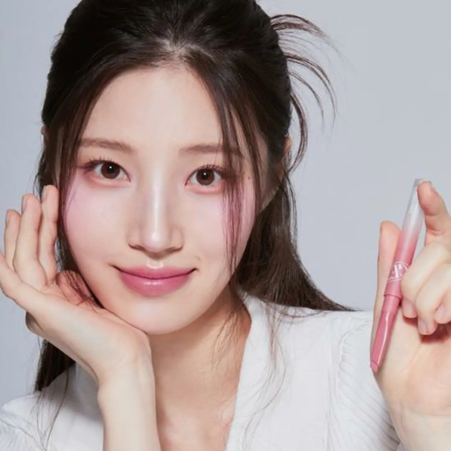 Woman holding TONY MOLY Get It Tint Lip Liner, showcasing the makeup product with a soft smile.
