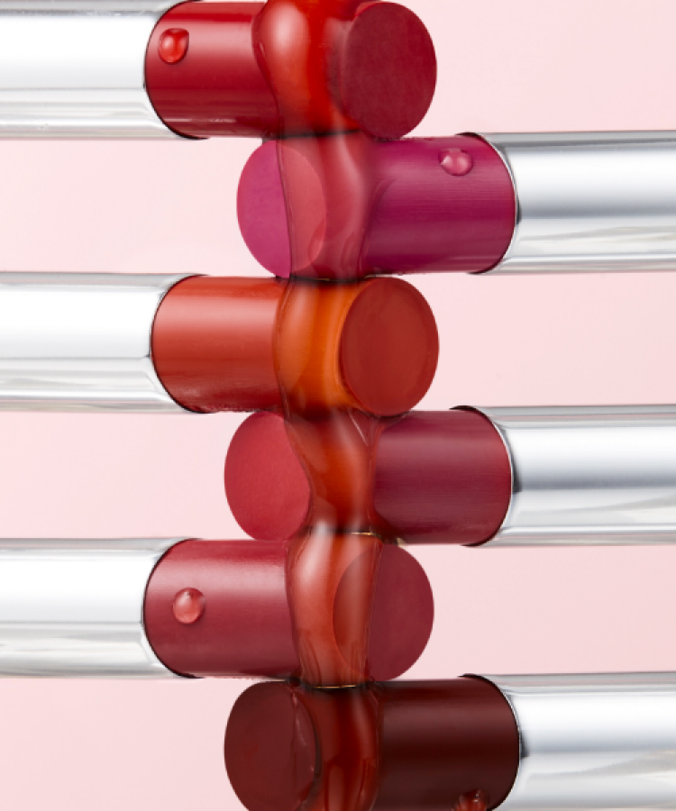 Colorful TONY MOLY Get It Tint Syrup Stick lipsticks arranged creatively against a pink background.