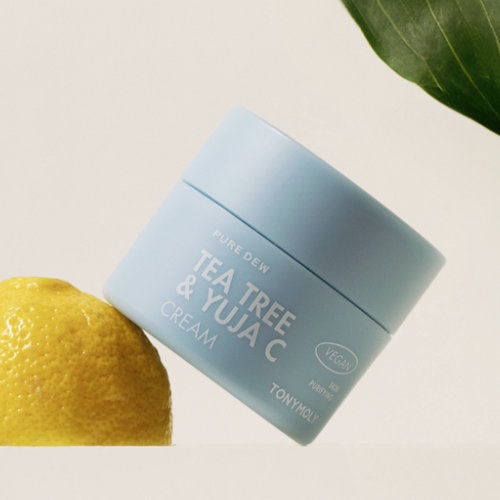 TONYMOLY Pure Dew Tea Tree & Yuja C Cream 50ml jar next to a yuja fruit