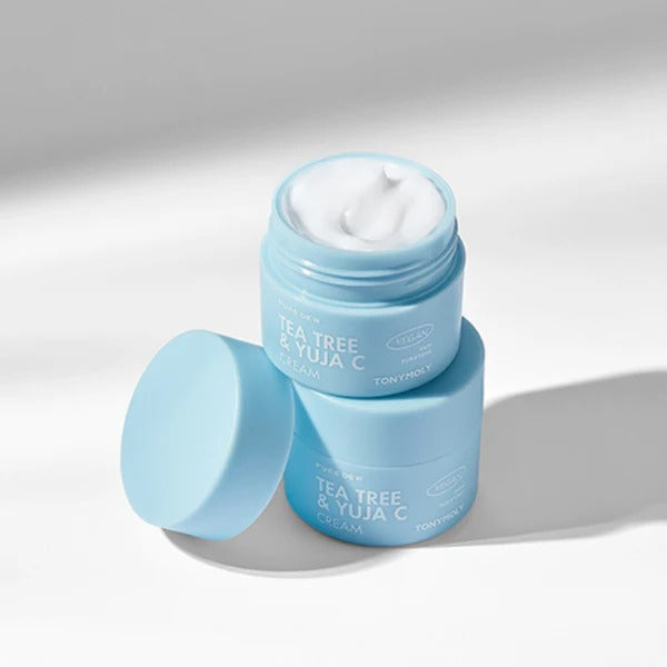 TONYMOLY Pure Dew Tea Tree & Yuja C Cream 50ml in light blue jar with lid off, showcasing the smooth texture of the cream.