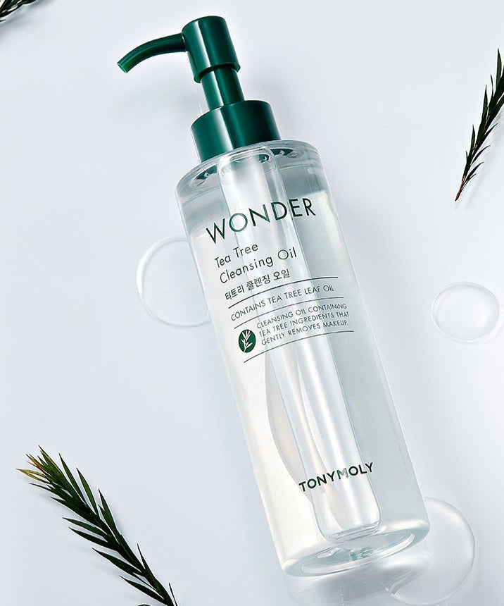 TONYMOLY Wonder Tea Tree Cleansing Oil 200ml bottle with green pump, surrounded by tea leaves on white background.