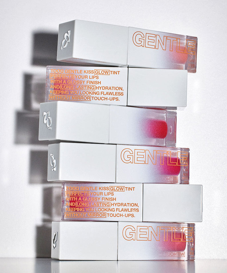 Stacks of TOOQ Gentle Kiss Glow Tint lip products showcasing packaging design and product branding.