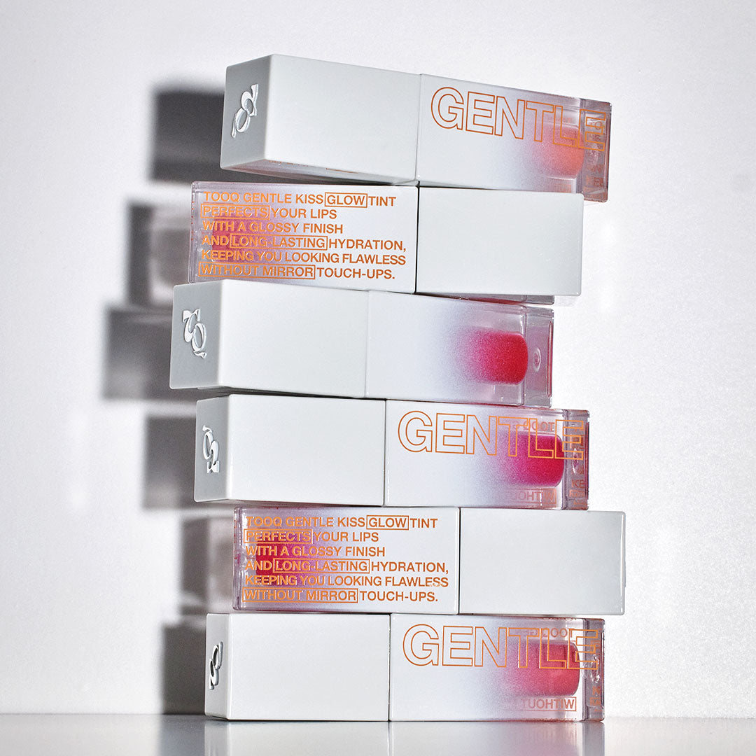 Stacks of TOOQ Gentle Kiss Glow Tint lip products showcasing packaging design and product branding.