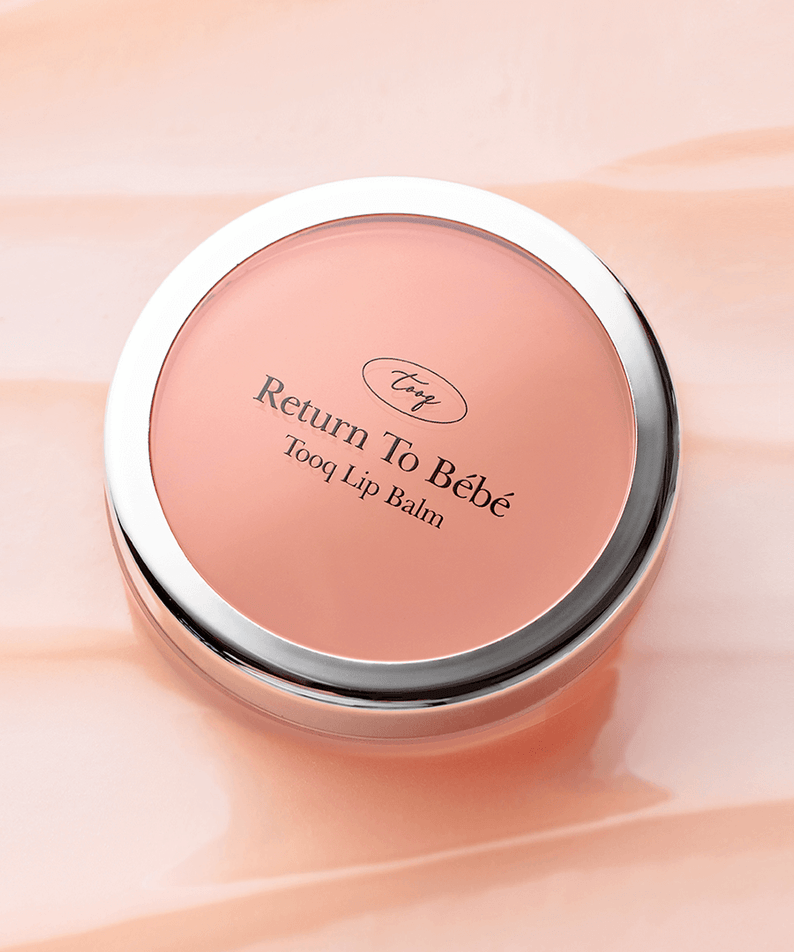 TOOQ Return To BÃ¨bÃ¨ Lip Balm in round container on peach background
