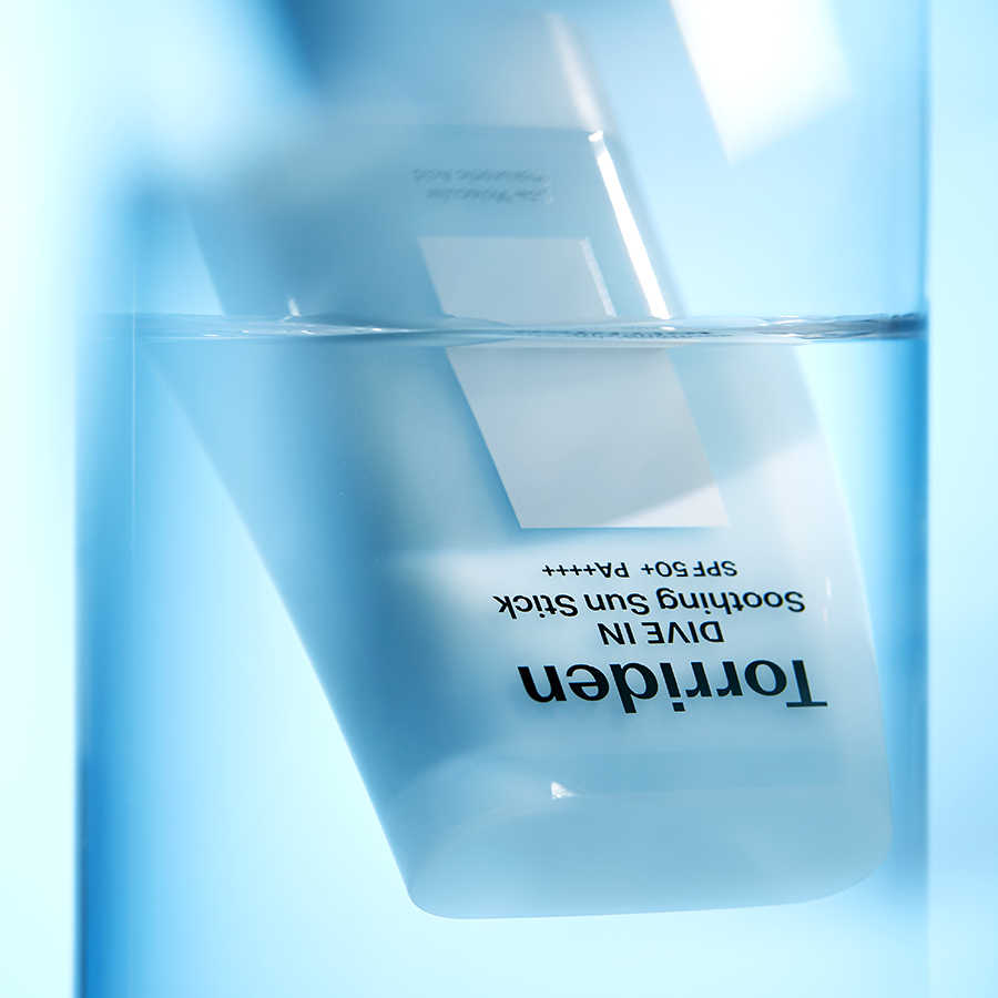 TORRIDEN Dive In Soothing Sun Stick SPF50+PA++++ 19g submerged in water.