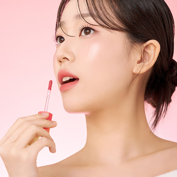 Model applying TOUCH IN SOL Vegan Again Blurcore Lip Tint with a natural finish.