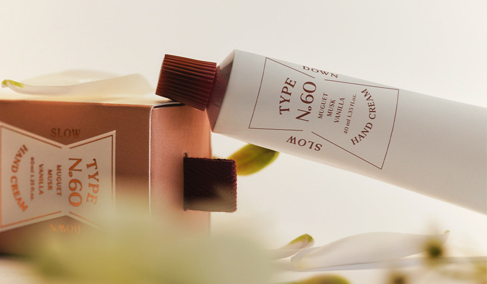 Type N.60 hand cream tube and box on a table with a soft focus background, promoting luxury skincare product.