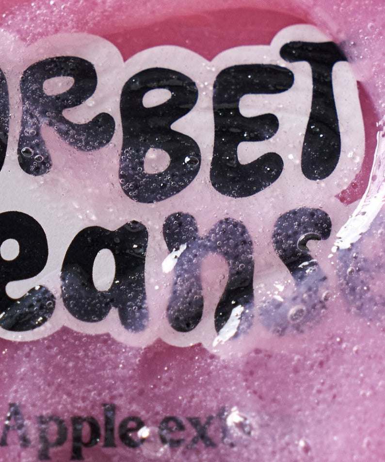 Close-up of UNLEASHIA ABC Sorbat Facial Cleanser 120ml, showing its vibrant pink color and apple extract bubbles.
