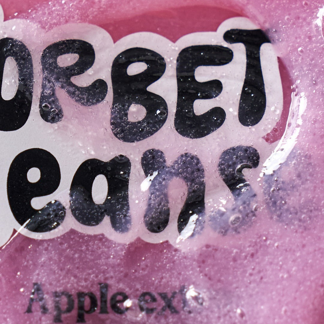 Close-up of UNLEASHIA ABC Sorbat Facial Cleanser 120ml, showing its vibrant pink color and apple extract bubbles.