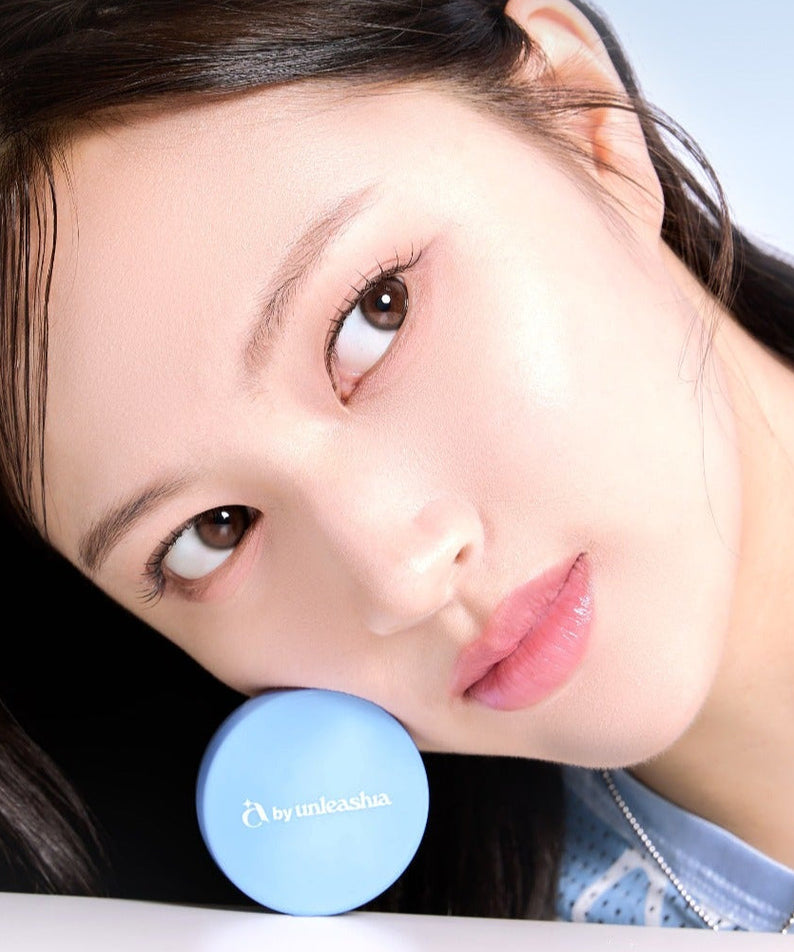 Woman with flawless skin holding UNLEASHIA Be Be Blue Cushion