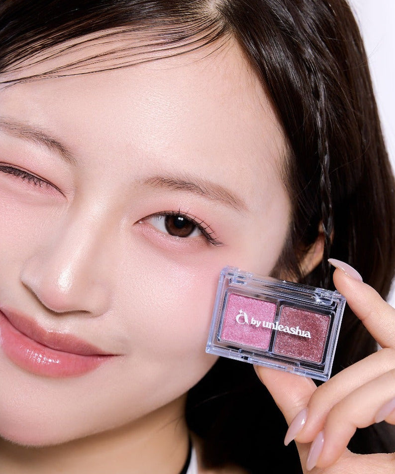 Model showcasing UNLEASHIA Cotton Candy Face Palette with pink hues and sleek design.