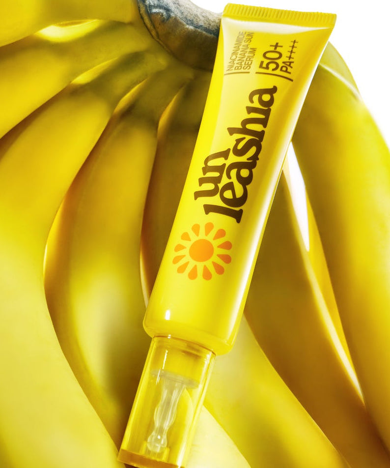 UNLEASHIA Niacinamide Banana Sun Serum 40ml with SPF 50+ displayed on a bright yellow banana background