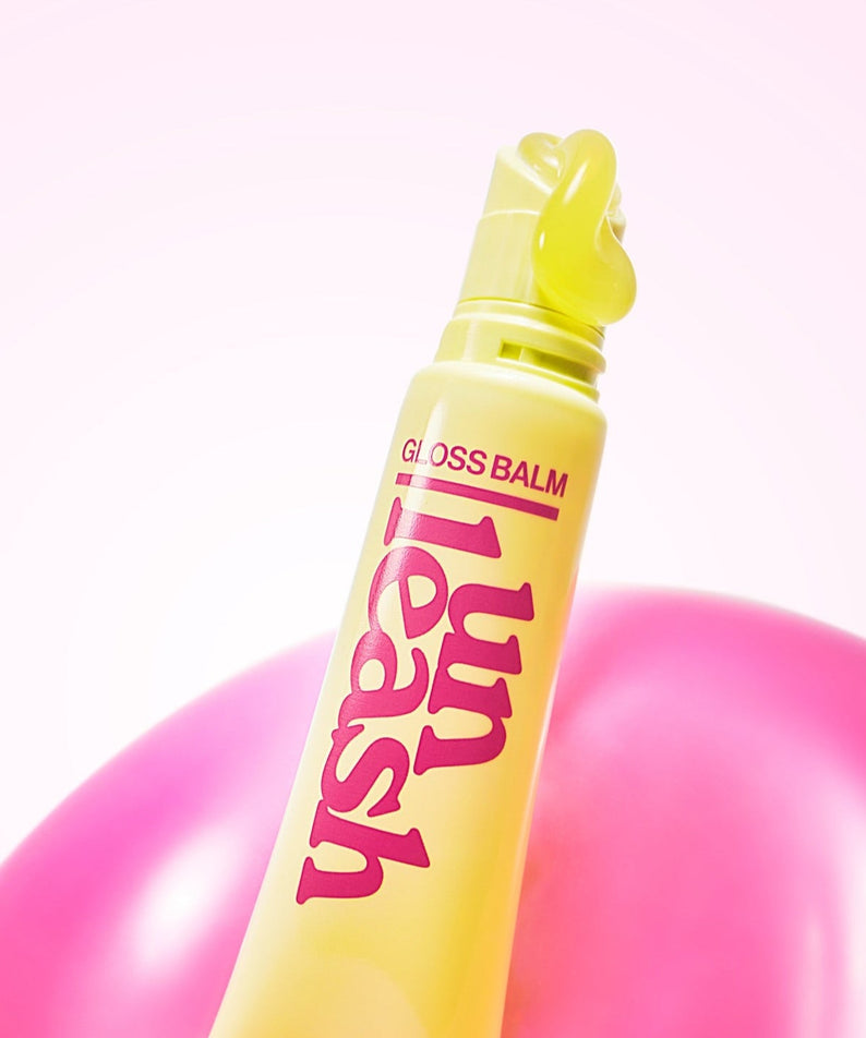 UNLEASHIA Sunset Dazzle Gloss Balm in vibrant yellow and pink packaging, perfect for glowing lips.