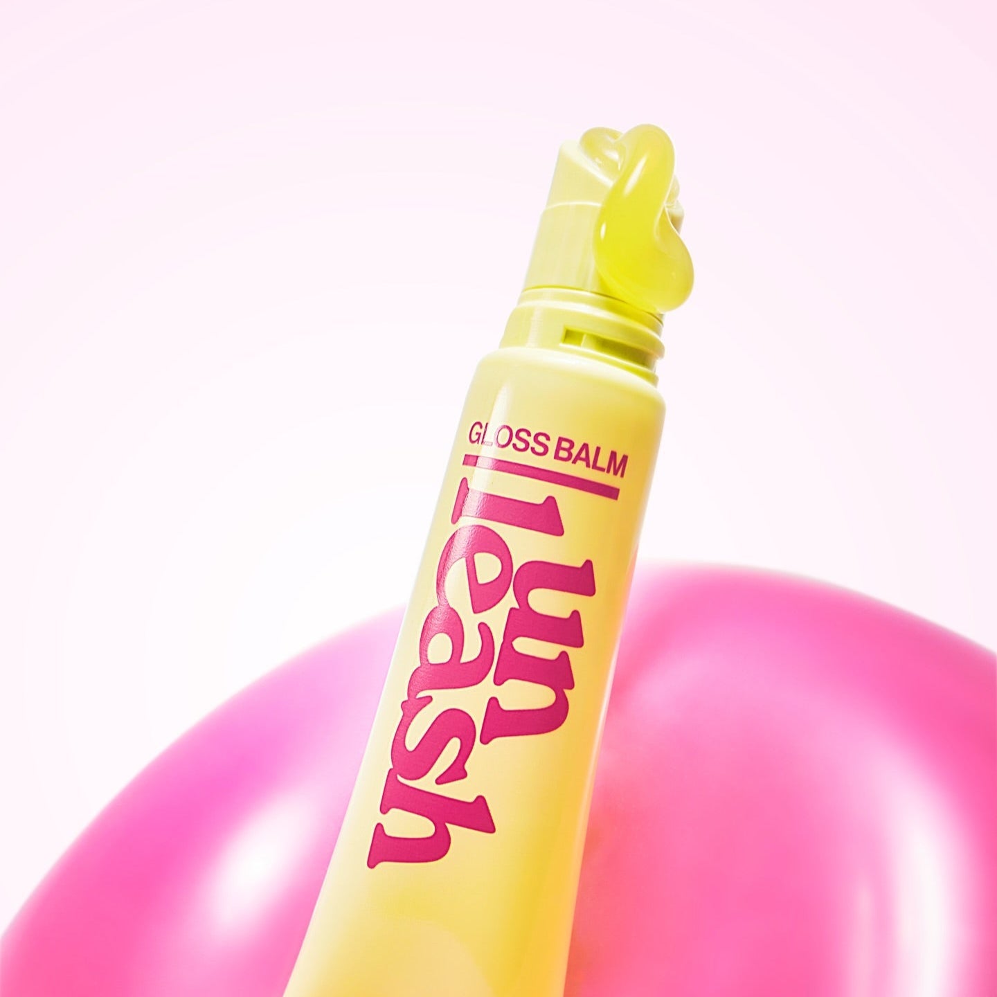 UNLEASHIA Sunset Dazzle Gloss Balm in vibrant yellow and pink packaging, perfect for glowing lips.