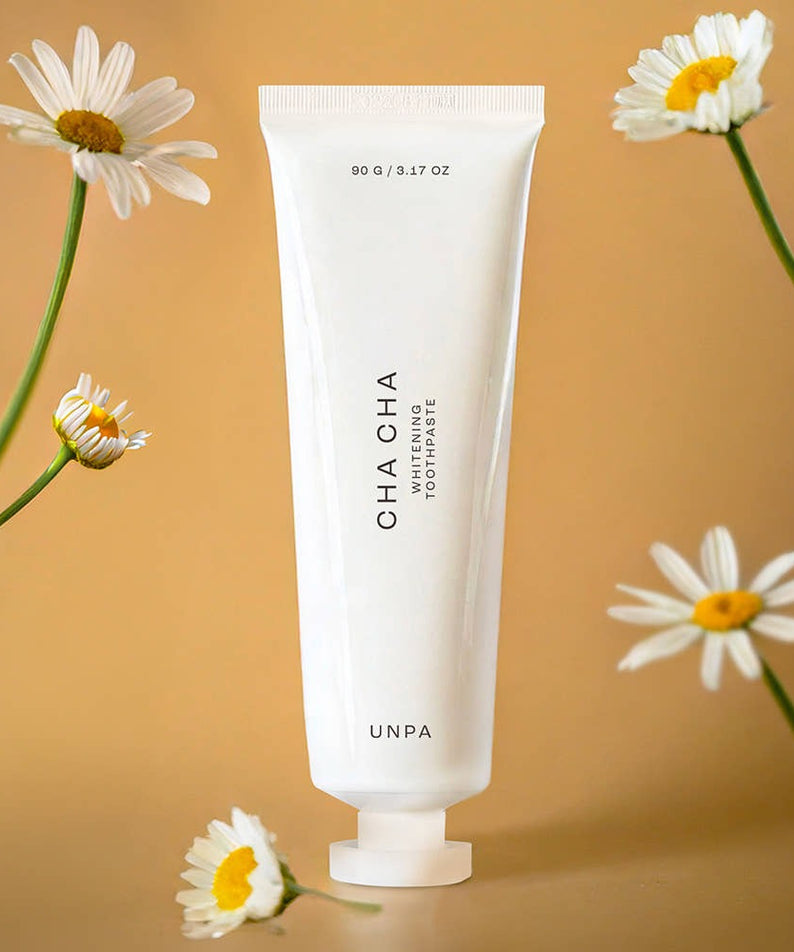 UNPA Chacha French Chamomile Vegan Whitening Toothpaste 90g with chamomile flowers on a beige background
