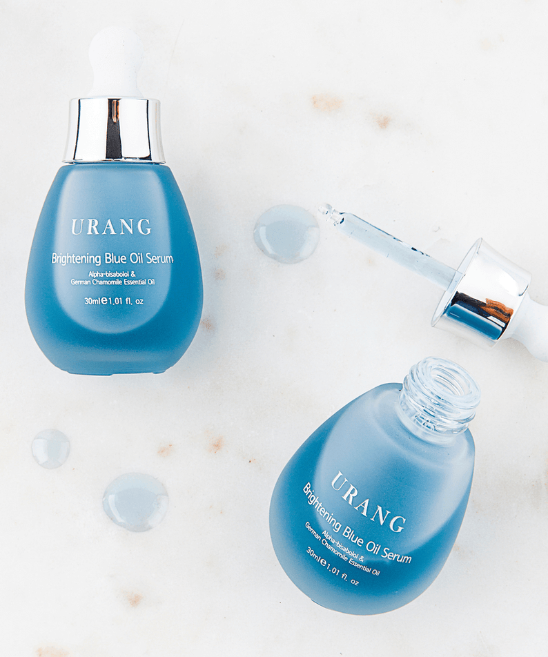 URANG Brightening Blue Oil Serum 30ml bottles and dropper on a marble surface