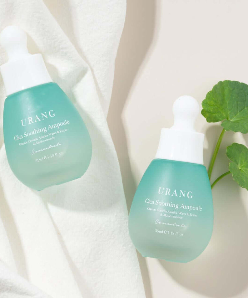 URANG Cica Soothing Ampoule bottles on white fabric with green leaves
