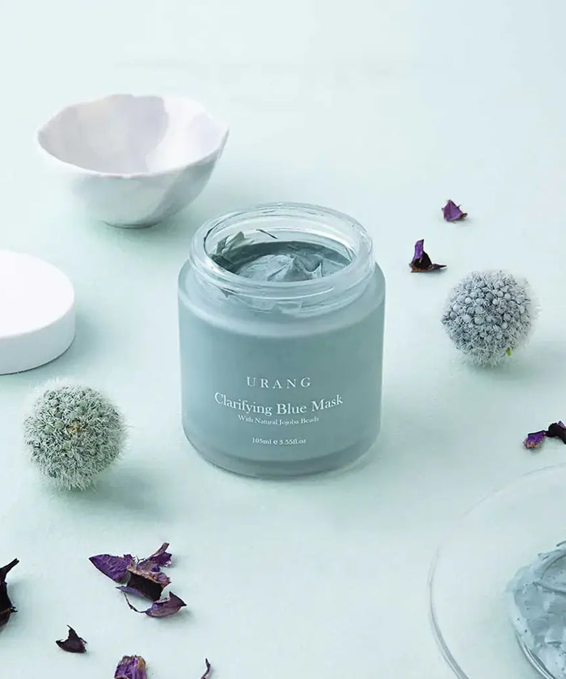 URANG Clarifying Blue Mask jar surrounded by decorative elements on a light background.
