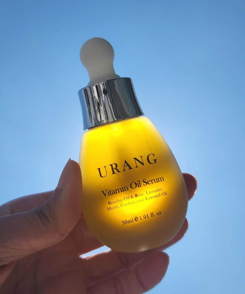 URANG Glow Oil Serum 30ml in sunlight showcasing luxurious skincare product in dropper bottle.