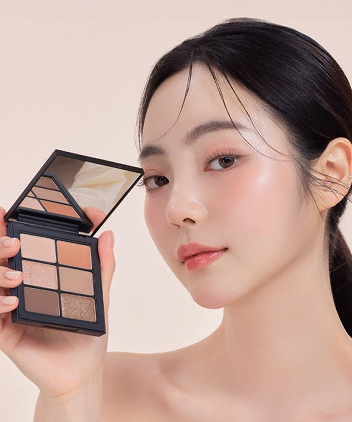 Person showcasing VIDIVICI Millennial Ambient Glow Eyes Palette with soft makeup look.