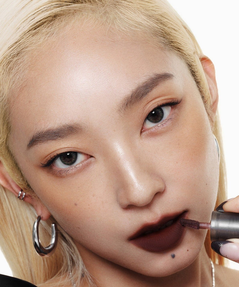 Model applying WAKEMAKE Soft Blurring Balm Stick for a soft, blurred lip effect.