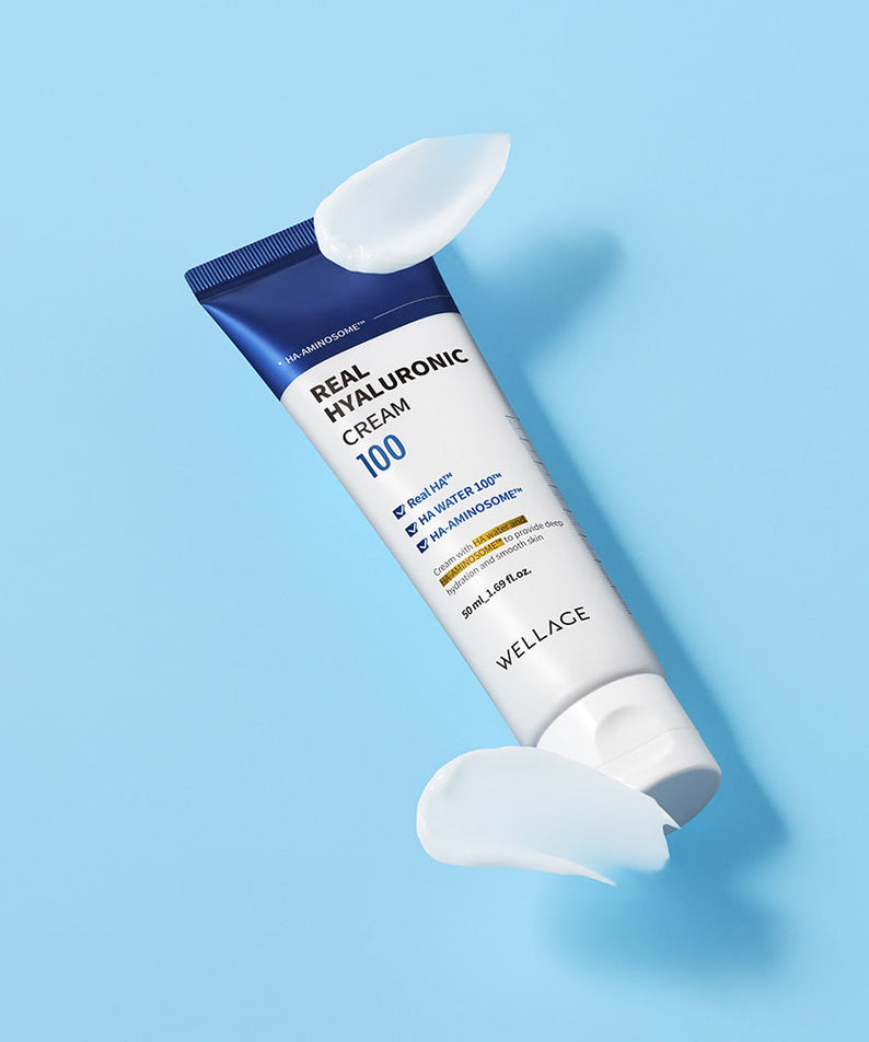 WELLAGE Real Hyaluronic 100 Cream 80ml tube on blue background with cream swirls.