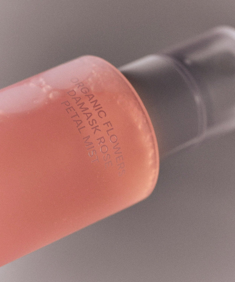 Bottle of WHAMISA Organic Flower Fermented Rose Petal Mist 100ml with pink liquid and pump dispenser