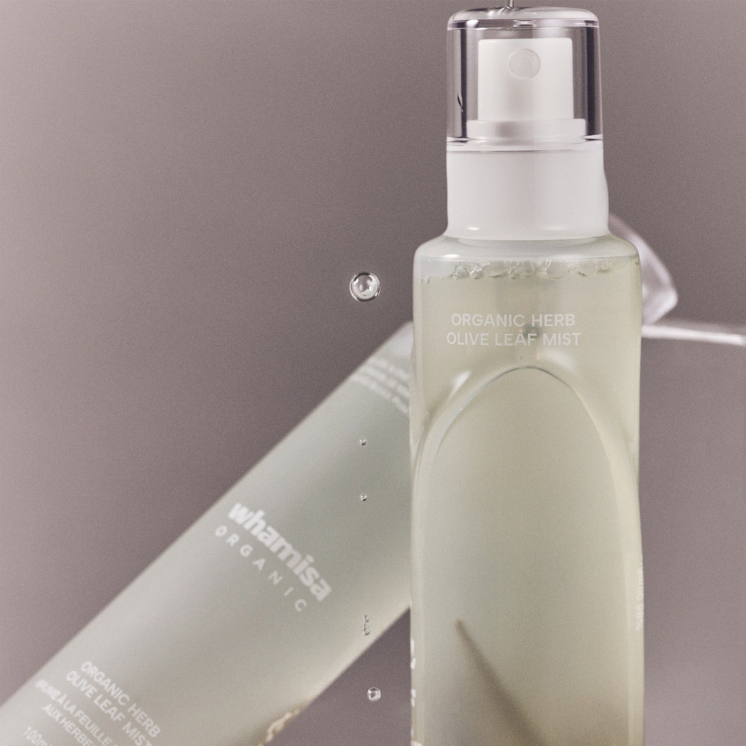 WHAMISA Organic Herb Fermented Olive Leaf Mist 100ml bottle with water droplets.