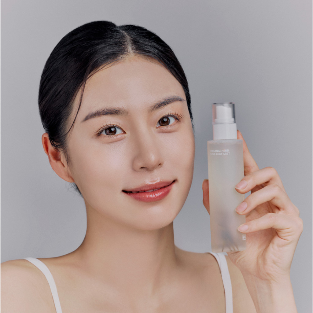 Model holding WHAMISA Organic Herb Fermented Olive Leaf Mist 100ml bottle