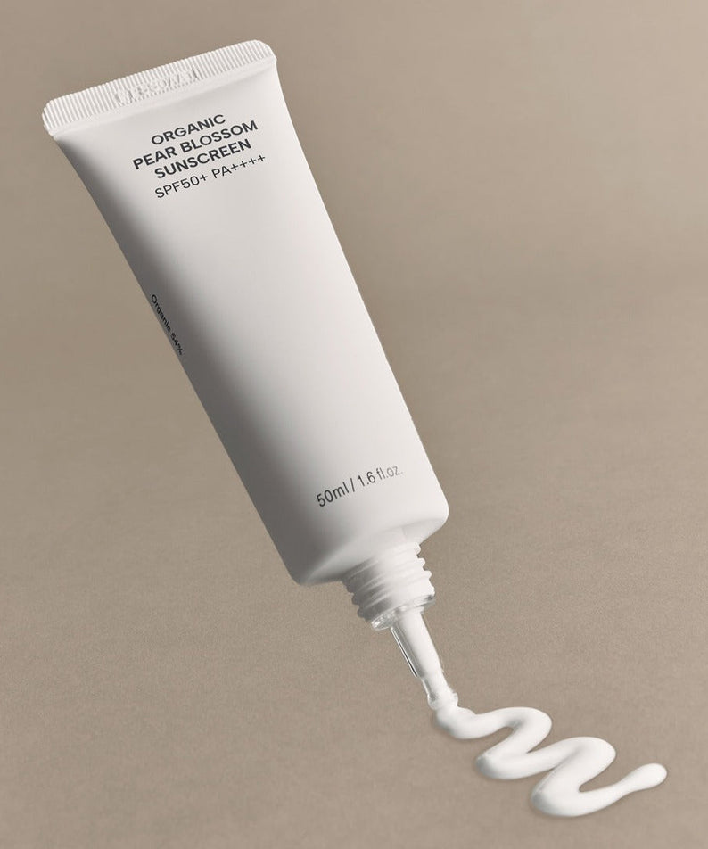 WHAMISA Organic Pear Blossom Fermented Sunscreen 50ml packaging with cream swirled on beige background.