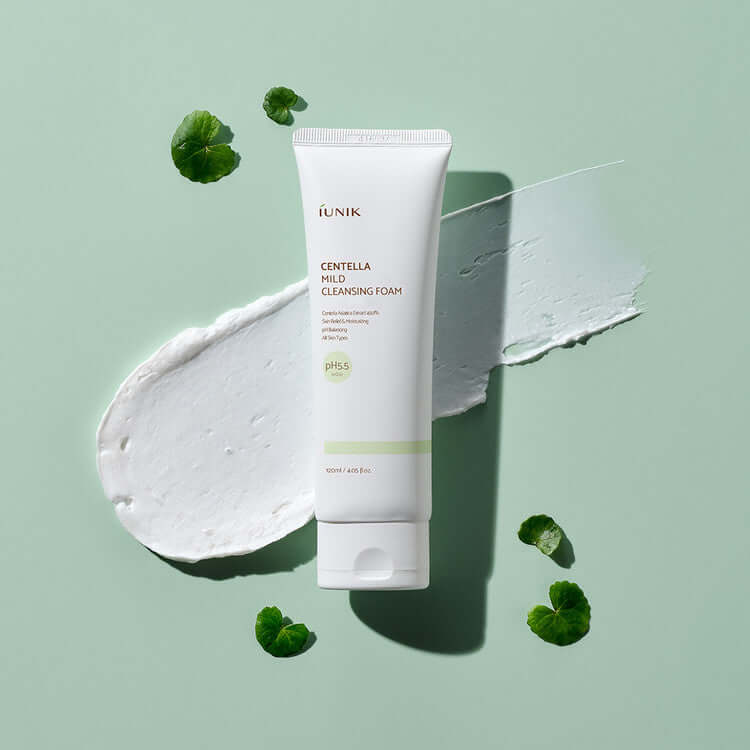 iUNIK Centella Mild Cleansing Foam 120ml on green background with texture smear and Centella leaves